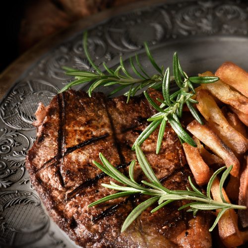 Bbq,Grilled,Sirloin,Steak,With,French,Fries,Against,A,Rustic